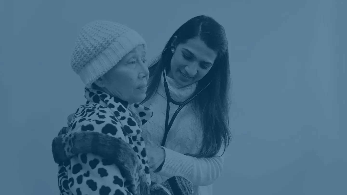 Physician examining an elderly patient with a stethoscope at JioMed Family Care in Leawood, KS
