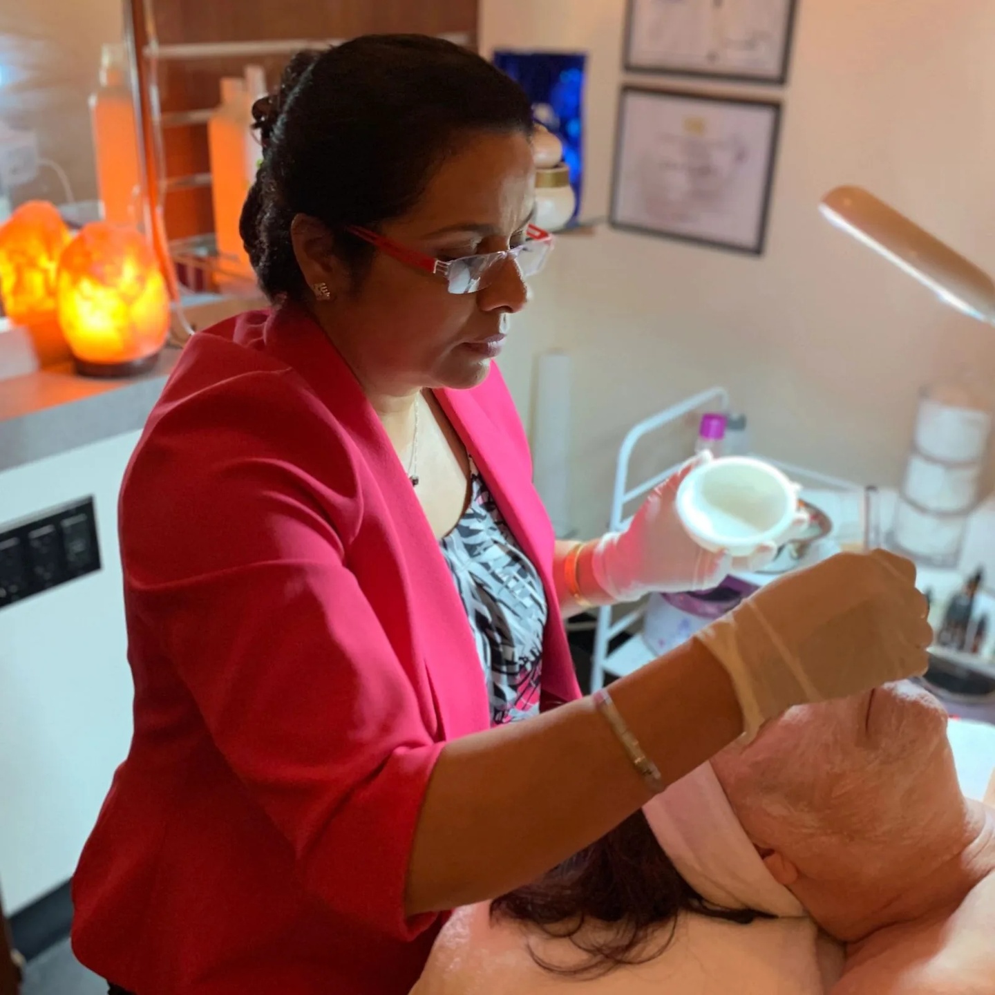 Harpreet applying a facial mask to a client