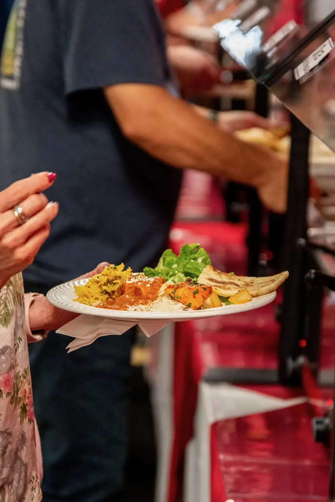 Guest holding a full plate at the buffet line