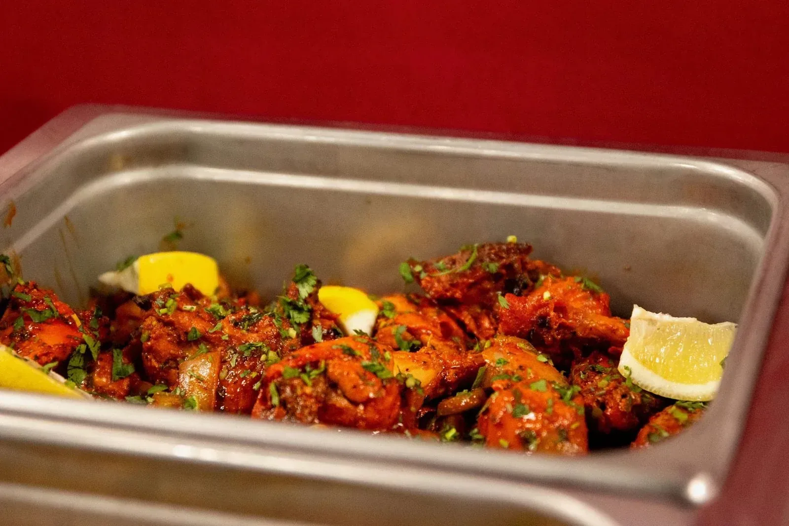 Tandoori chicken with onions and lemon wedges