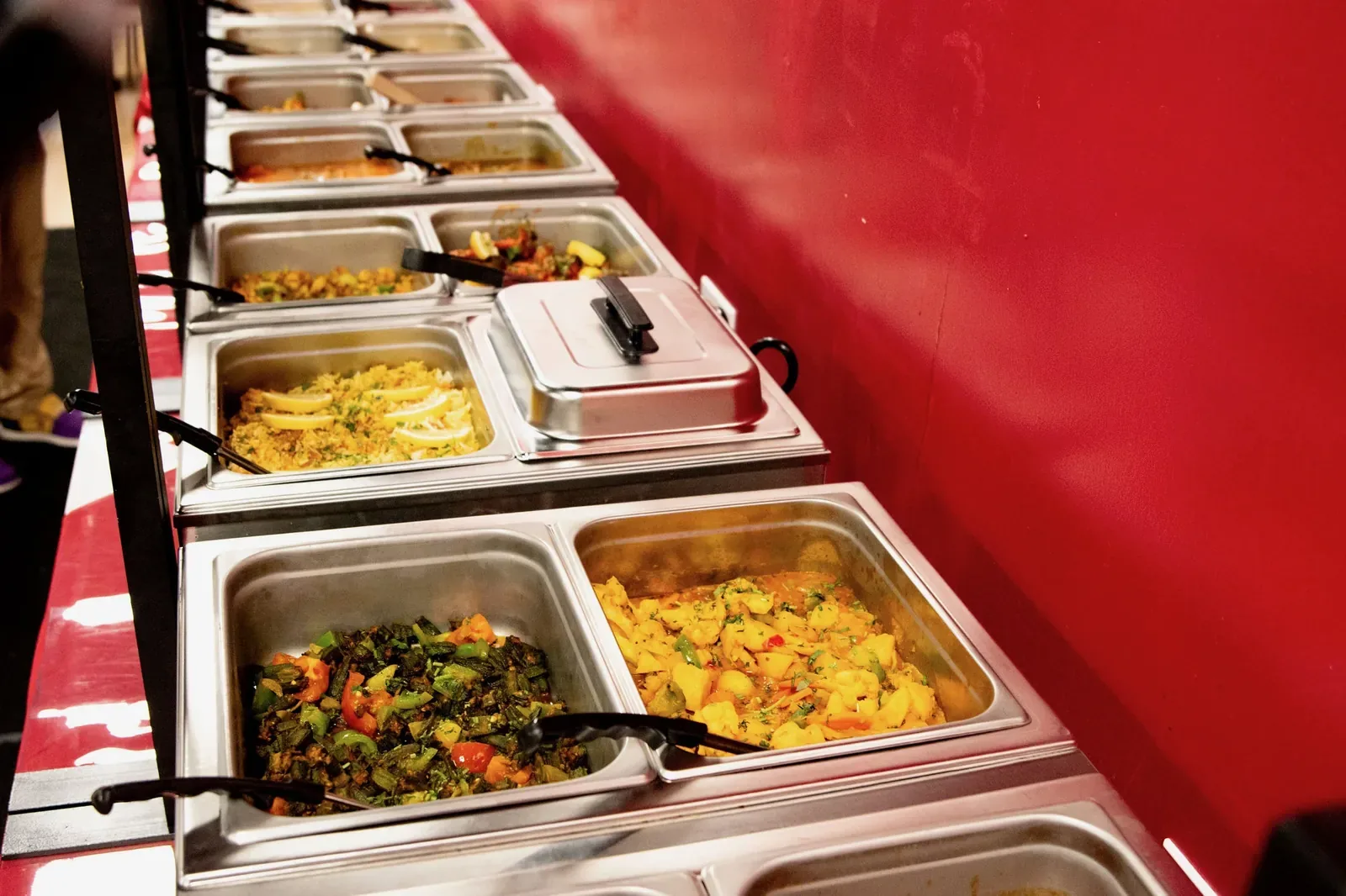 Lunch buffet steam trays along the red dining-room wall