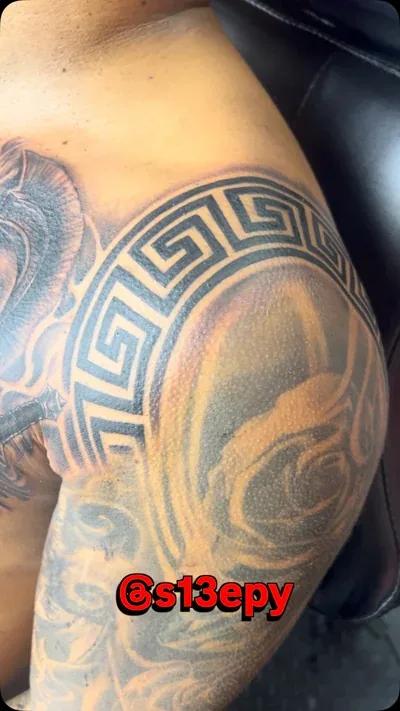 Black and grey tattoo of a lion and a warrior
