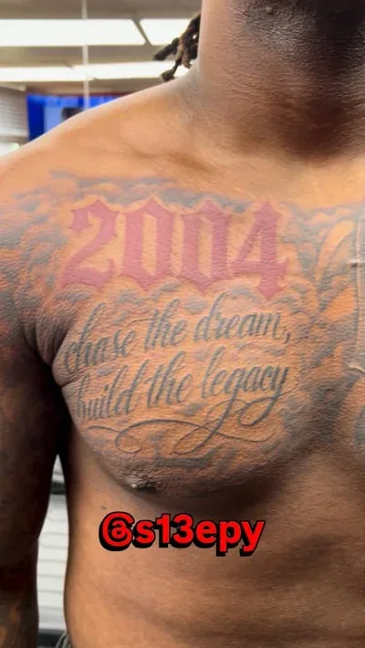 Chest lettering tattoo reading 2004, chase the dream, build the legacy, completed in a single session