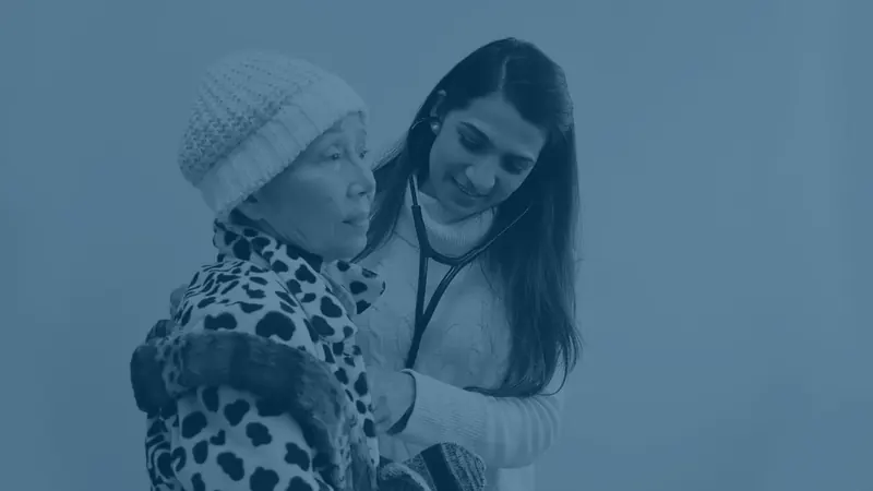 Physician examining an elderly patient with a stethoscope at JioMed Family Care in Leawood, KS